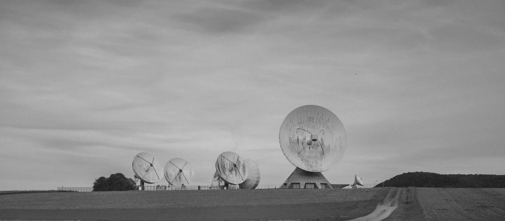 Communication dishes in a field, black and white